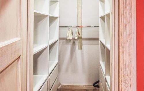a closet with white shelves and a door at 3 Bedroom Amazing Home In Kopalino in Kopalino