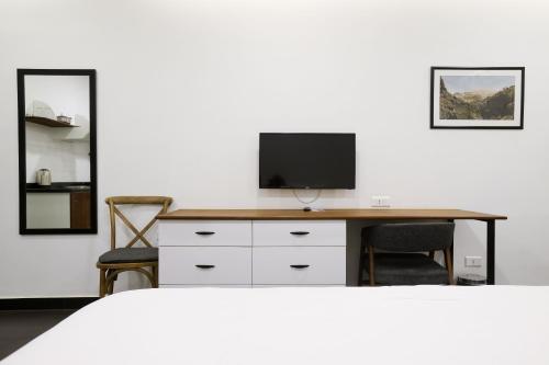 a bedroom with a desk with a television on it at Hamra Urban Gardens in Beirut
