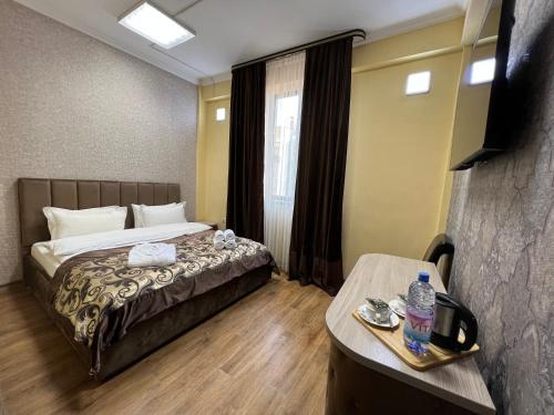 pokój hotelowy z łóżkiem i stołem w obiekcie DeLuxe PLAZA w mieście Ałma-Ata