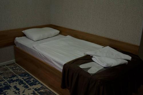 a bed with white sheets and pillows on it at DAVAN in Koshkurgan