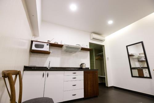 a kitchen with a sink and a microwave at Hamra Urban Gardens in Beirut