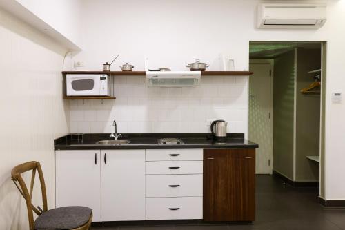 a small kitchen with a sink and a microwave at Hamra Urban Gardens in Beirut