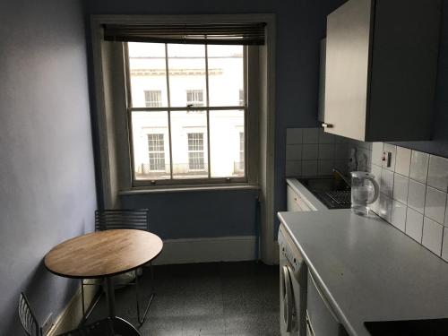 a small kitchen with a table and a window at Kensington flat with roof terrace and sunshine in London
