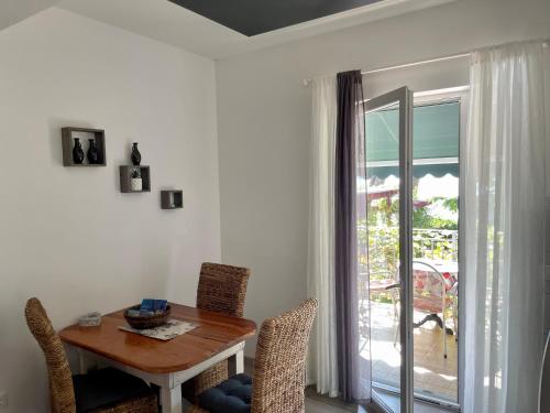 uma sala de jantar com uma mesa e cadeiras e uma janela em Villa Joška em Brela