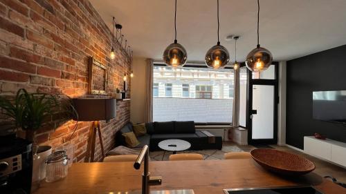 a living room with a brick wall and a table at Designwohnung Schaufenster sehr zentral gelegen in Hannover