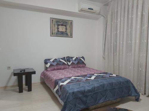 um pequeno quarto com uma cama e uma janela em MIA apartment em Skopje