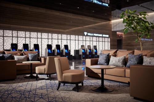 a waiting room with couches and chairs and tables at Villa Fontaine Grand Haneda Airport in Tokyo