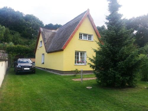 a car parked in front of a yellow house at Ferienhaus Juhnke in Kamminke