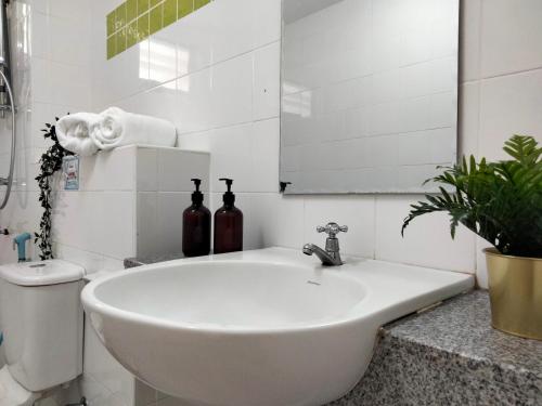 Baño blanco con lavabo y espejo en Cyberia Crescent - 3 bedroom 8 Pax, en Cyberjaya