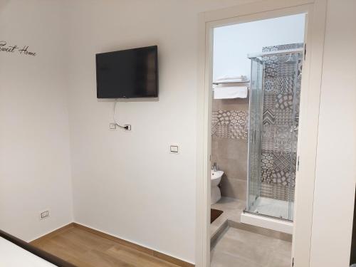 łazienka z toaletą i telewizorem na ścianie w obiekcie Sunset House w mieście Balestrate