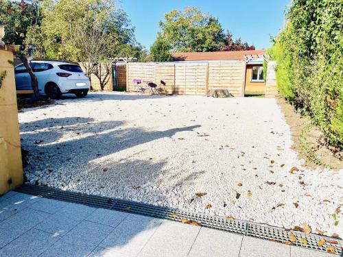 a driveway with a car parked in a yard at SECRET GARDEN parking hyper centre & calme in Claye-Souilly