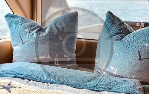 two blue pillows sitting on a bed in a car at Awesome Ship In Neuruppin With Kitchen in Neuruppin