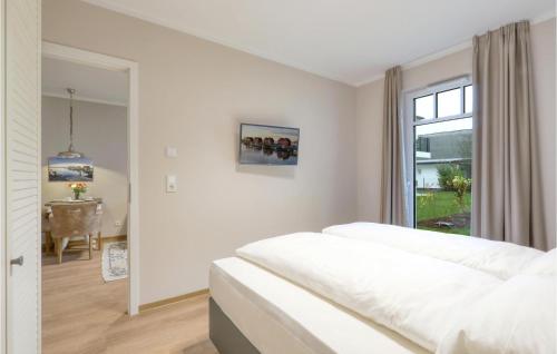 ein weißes Schlafzimmer mit einem Bett und einem Fenster in der Unterkunft Baltischer Hof Apartment 13 in Boltenhagen