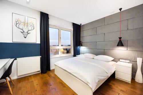 Un dormitorio con una gran cama blanca y una pared en Qbik Artistic Cityscape Apartment, en Varsovia