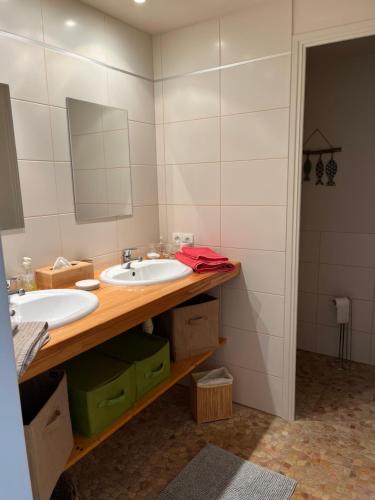 Baño con 2 lavabos y espejo en Chambre d’hotes golf du Morbihan, en Plougoumelen