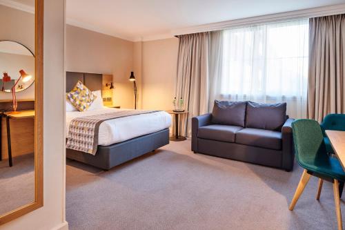 a hotel room with a bed and a couch at Holiday Inn Reading South M4 Jct 11 by IHG in Reading