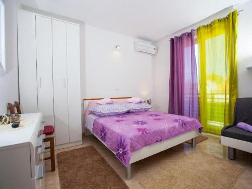 ein Schlafzimmer mit einem lila Bett und einem Stuhl in der Unterkunft Lux apartment Mare By the Sea & Beach in Baška Voda