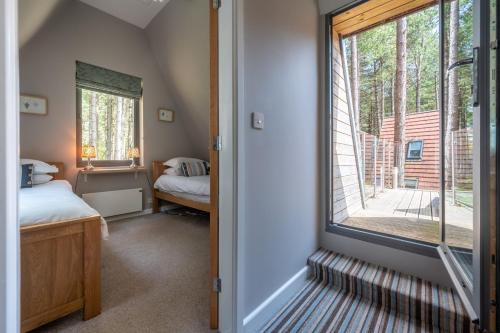 a room with a window and a bedroom with a bed at Liz's Lodge by Big Skies Cottages in Weybourne