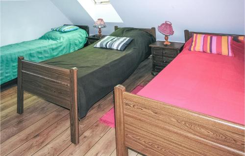 um quarto com 2 camas e uma colcha vermelha em 3 Bedroom Amazing Home In Jedwabno em Jedwabno
