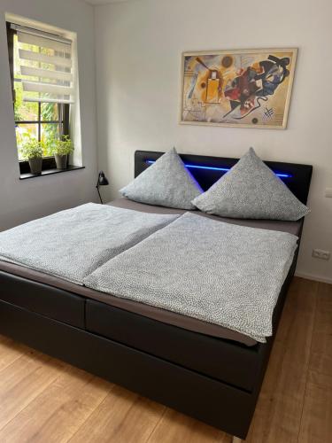 a bedroom with a black bed with pillows on it at City Park Loft in Münchberg
