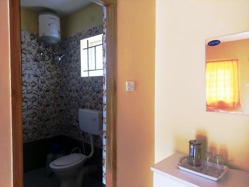 a bathroom with a toilet and a window at JRS INN, KODAIKANAL in Kodaikānāl