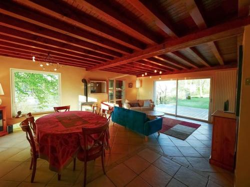 a living room with a table and a dining room at Gite des Marronniers in Dizimieu