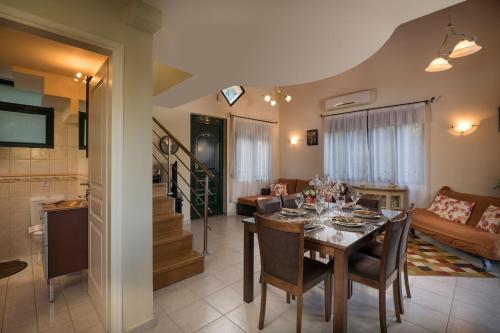 a dining room and living room with a dining table at Villa La Palma in Vrísai