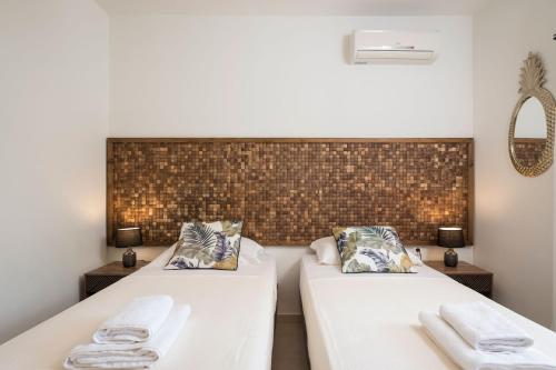 two beds in a room with white sheets and pillows at Villa La Palma in Vrísai