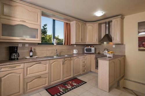 a kitchen with wooden cabinets and a window at Villa La Palma in Vrísai
