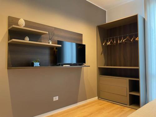 a living room with a tv and a closet at Nicarè City Apartments in Palermo