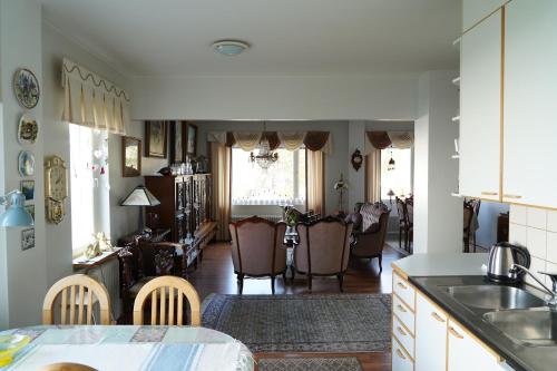 cocina y sala de estar con mesa y sillas en Brahenkatu Apartment en Kajaani