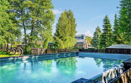 a swimming pool in a yard with trees at Amazing Apartment In Nidzica With Sauna, 2 Bedrooms And Heated Swimming Pool in Nidzica