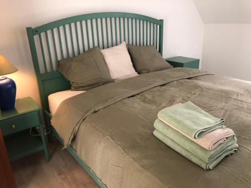 zielone łóżko z dwoma ręcznikami na górze w obiekcie Giorgio w Antwerpii