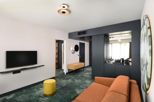a living room with a couch and a tv at Mercure Debrecen in Debrecen