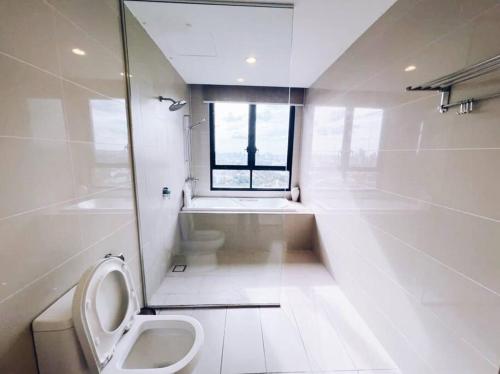 a white bathroom with a toilet and a window at [PROMO]Connected train 2 Bedrooms - Above Mall(25) in Kuala Lumpur