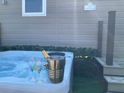 a bottle of champagne in a bucket next to two wine glasses at Unwind@36 Lodge in Felton