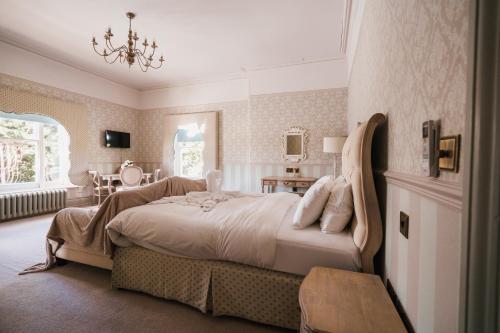 a bedroom with a large bed with a chandelier at St Andrews Town Hotel in Droitwich