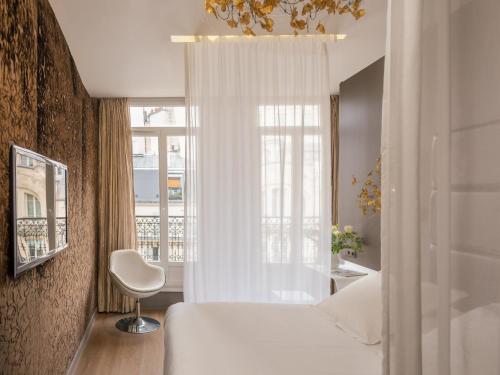 ein Schlafzimmer mit einem weißen Bett und einem Fenster in der Unterkunft Legend Hôtel Paris in Paris