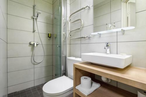 a bathroom with a toilet and a sink and a shower at Koidulapark Hotell in Pärnu