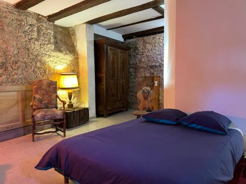 1 dormitorio con 1 cama de color púrpura y 1 silla en Domaine La Cour Des Nobles - Demeure, Maison et Appartements au coeur de Riquewihr, en Riquewihr