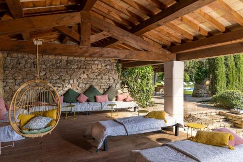 un patio con sofás y una silla colgante en La Magdeleine - Mathias Dandine, en Gémenos