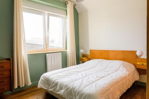 Schlafzimmer mit einem Bett und einem Fenster in der Unterkunft Vacances Bigoudenes pour 6 ! in Loctudy