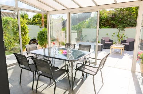 une salle à manger avec une table et des chaises en verre dans l'établissement Vacances Bigoudènes pour 6 !, à Loctudy