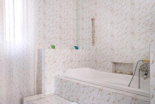 uma casa de banho branca com uma banheira e um chuveiro em Suite in villa con parco em Varese