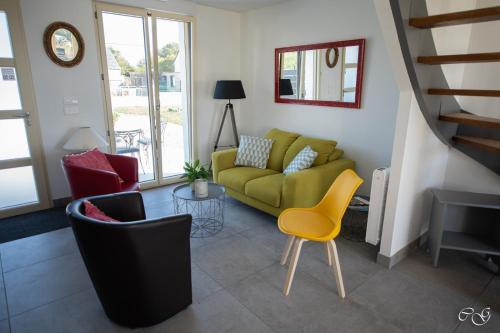 a living room with a green couch and chairs at GITE ARC EN CIEL BLEU in Férel