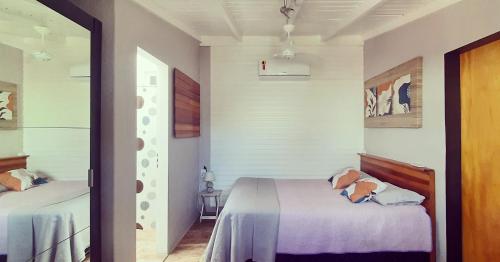 een slaapkamer met 2 bedden in een kamer met een raam bij Villacasamarela mini casinhas de hospedes Rio vermelho in Florianópolis