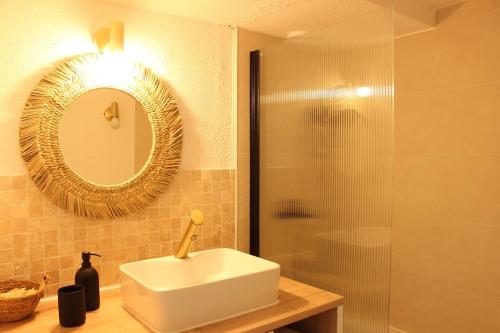 a bathroom with a sink and a shower with a mirror at Le 41 - Cosy et Confort in Barèges