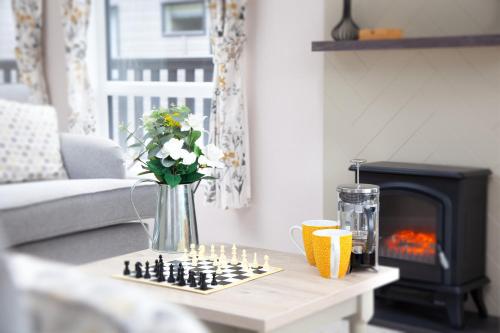 a living room with a vase of flowers on a table at Lakeside Lodge, Green Hill Farm Holiday Village in Salisbury