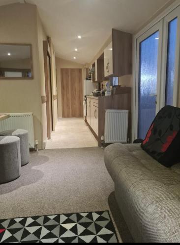 a living room with a couch and a kitchen at Lyons Winkups towyn 6 berth fully adapted caravan in Kinmel Bay