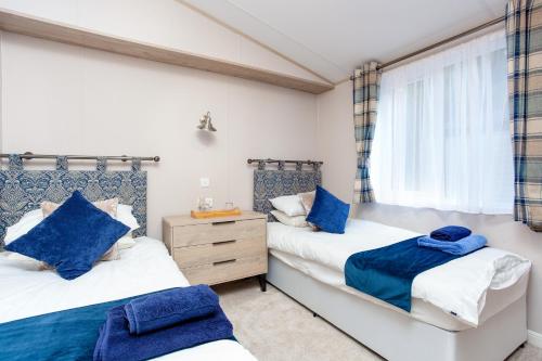 a bedroom with two beds and a window at Lakeside Lodge, Green Hill Farm Holiday Village in Salisbury